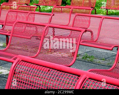 File con sedie in metallo rosso e sfondo verde Foto Stock