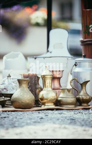 Teiera antica, crema e altri utensili in un mercato delle pulci. Vecchio metallo stoviglie a una vendita garage. Foto Stock