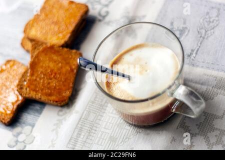 La colazione del mattino con cappuccino schiumoso e toast con marmellata. Cibo e caffè. Colazione in hotel Foto Stock