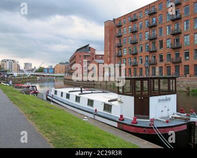 le case galleggianti ormeggiate sul canale leeds-liverpool nel con appartamenti lungo il fiume e la zona portuale e la città di clarence Foto Stock