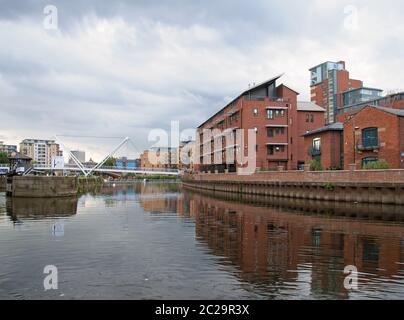 il fiume aire si unì al canale leeds liverpool nell'area portuale di clarence con edifici che si riflettono nelle chiuse d'acqua e nei bri Foto Stock