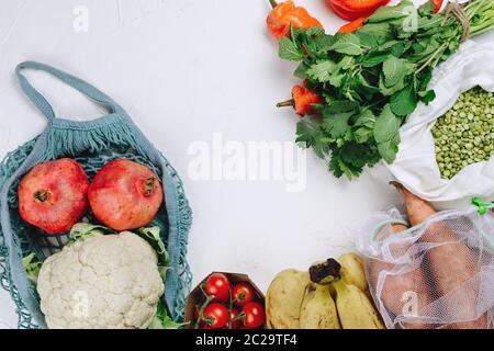 Concetto di shopping alimentare sostenibile a zero rifiuti: Uva, pomodori, piselli, verdi, nocciole, ecc. in sacchetti di produzione Foto Stock