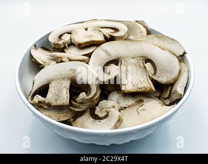 Funghi champignon freschi in una ciotola isolata su bianco Foto Stock