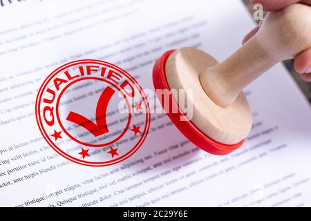 Imprenditore mettendo mano qualificati timbro sul documento Foto Stock
