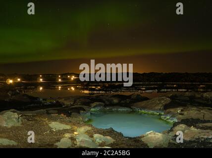 Un sentiero illuminato di fronte alla laguna blu con luci del nord Foto Stock