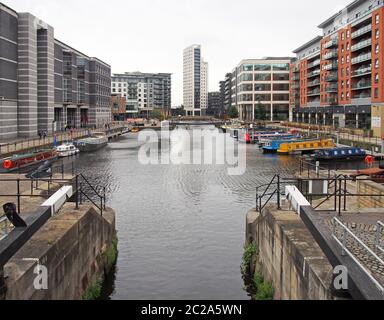 una vista del molo di leeds dalle porte di chiusura con case galleggianti ormeggiate accanto agli edifici sul mare Foto Stock