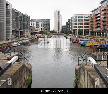 una vista del molo di leeds dalle porte di chiusura con case galleggianti ormeggiate accanto agli edifici sul mare Foto Stock