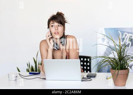 Freelance che lavora sul telefono e sul laptop Foto Stock