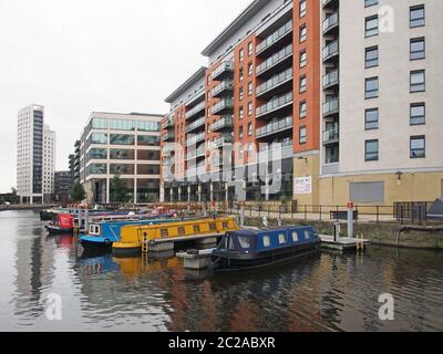 vecchie case galleggianti ormeggiate accanto a moderni edifici di appartamenti a leeds ormeggiano nella parte occidentale dello yorkshire Foto Stock