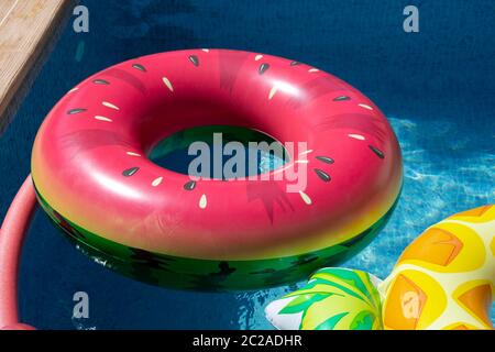 Gonfiabile anello di melone galleggianti in piscina Foto Stock