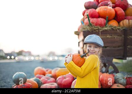 Felice bambina all'autunno zucca patch sfondo. Avendo divertimento. Tonica in stile retrò Foto Stock