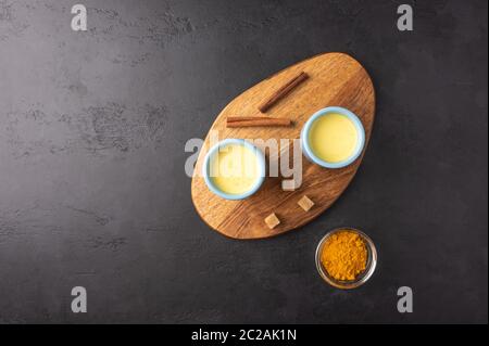 Due tazze blu in ceramica con tradizionale tè indiano masala chai con zucchero sul tagliere. Vista dall'alto con spazio per la copia Foto Stock