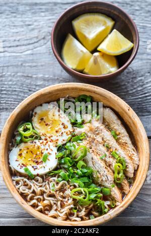 Ciotola di zuppa di ramen di pollo sul tavolo di legno Foto Stock