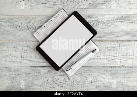 Nero tavoletta elettronica e carta del notebook su vintage shabby bianco sullo sfondo di legno. La vista dall'alto. laici piatta Foto Stock