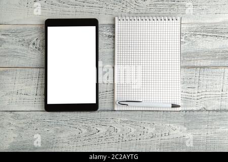 Nero tavoletta elettronica e carta del notebook su vintage shabby bianco sullo sfondo di legno. La vista dall'alto. laici piatta Foto Stock