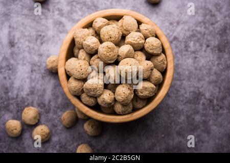 Pezzi di soia grezzi, carne di soia per vegani isolati su sfondo colorato in una ciotola o in forma di cumulo Foto Stock