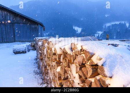 Legna da ardere vicino a un fienile nella luce Foto Stock