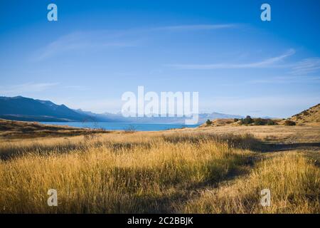 Vista panoramica dalla riva del lago Pukaki, Nuova Zelanda, in una calda serata estiva con il Monte Cook visibile in lontananza. Foto Stock