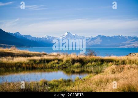 Vista panoramica dalla riva del lago Pukaki, Nuova Zelanda, in una calda serata estiva con il Monte Cook visibile in lontananza. Foto Stock