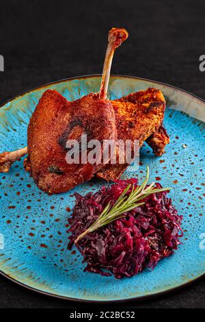 Anatra confit gambe e cavolo rosso con prugne secche Foto Stock