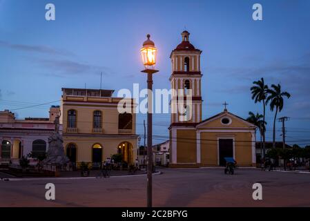 Suggestiva piazza centrale con una chiesa e lampada da strada illuminata, Remedios, Cuba Foto Stock