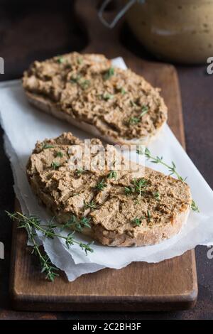 Freschi Fatti in casa di fegato di pollo patè. Fegato di pollo pate sul pane e nel vaso su uno sfondo scuro/ Foto Stock