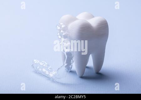 Close-up trasparente di protezione Bocca e dente bianco modello su sfondo blu Foto Stock