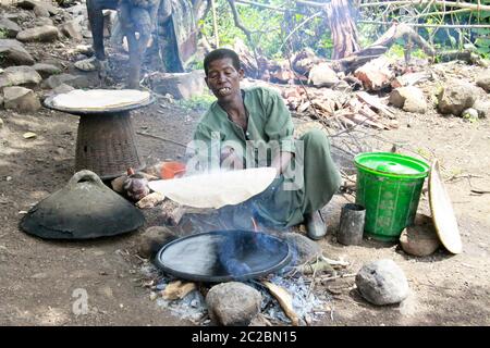 Africa, Etiopia, Lalibela, Donna cuoce injera (injera è un pane piatto lievitato con una consistenza unica e leggermente spugnosa. Tradizionalmente fatto fuori o Foto Stock