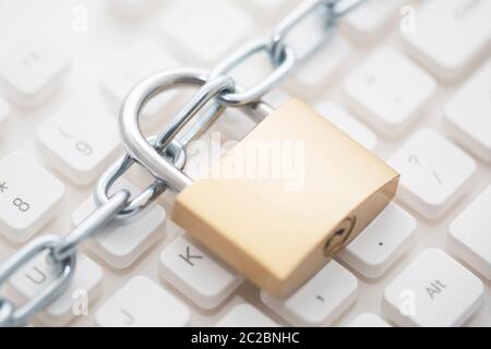 Concetto di sicurezza con lucchetto in metallo e la catena sulla tastiera del computer Foto Stock