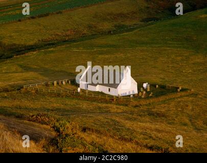 Vista e della chiesa di Santa Croce guardando giù dal promontorio di Foel y Mwnt, Cardigan; Galles; Regno Unito. Costruito 13 °-C14 sul sito della cella di un santo celtico. Foto Stock