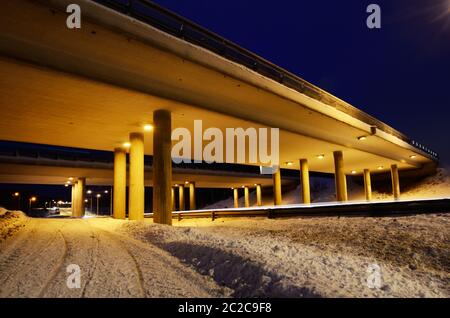 Viadotto in una notte d'inverno illuminata da lampade stradali Foto Stock