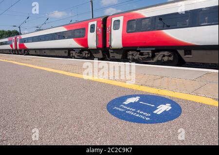 Contrassegno su una piattaforma della stazione ferroviaria che chiede alle persone di rispettare la regola di distanza sociale di 2 metri a causa della pandemia del coronavirus nel giugno 2020, Regno Unito. Foto Stock