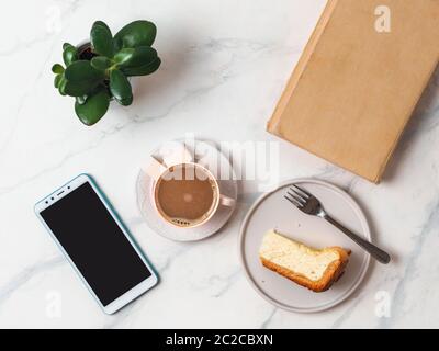 Caffè, cheescake, smartphone sul tavolo Foto Stock
