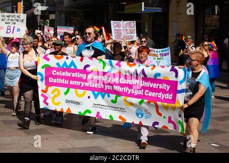Banner bilingue e marchers dell'Università di Cardiff al 2019 marzo gay Pride a Cardiff, Pride Cymru. Foto Stock