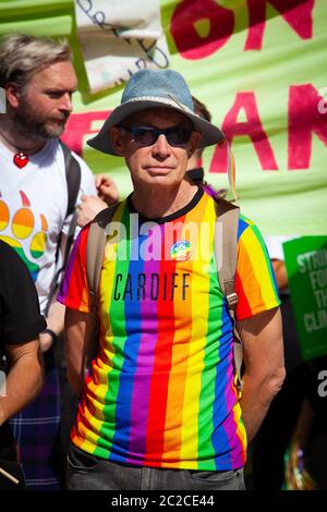 Uomo in LGBTQI t-shirt arcobaleno colorata al Pride Cymru marzo a Cardiff, 2019 Foto Stock