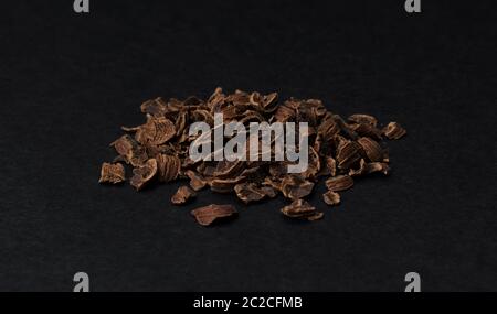 Il cioccolato grattugiato. Heap di massa di cioccolato isolato su sfondo nero, primo piano Foto Stock