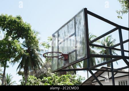 Vecchio cerchio rustico di basket grunge nel verde selvaggio della foresta tropicale. Scuola parco giochi quartiere Foto Stock