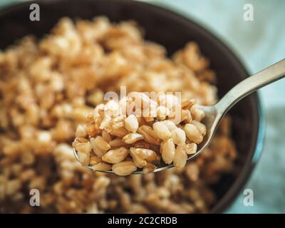 farro bollito in cucchiaio, fuoco selettivo Foto Stock