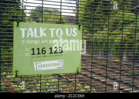 I Samaritani firmano, parte della loro campagna annuale di sensibilizzazione nelle comunità locali. Qui è su una recinzione da una ferrovia e un ponte whi Foto Stock