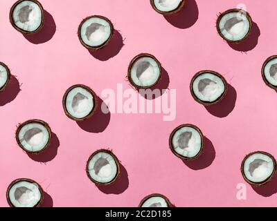 Noci di cocco a metà su sfondo rosa Foto Stock