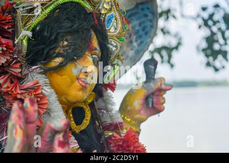 Un dipositivo di Maa Durga tristemente guarda giù con tousled i capelli durante il flusso di lacrime agli occhi durante la Durga Maa visarjan o immersione a Ganga o fiume Gange. Esso refl Foto Stock