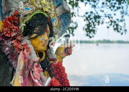 Un dipositivo di Maa Durga tristemente guarda giù con tousled i capelli durante il flusso di lacrime agli occhi durante la Durga Maa visarjan o immersione a Ganga o fiume Gange. Esso refl Foto Stock