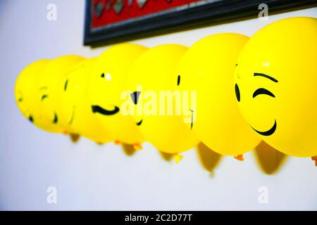 Decorazione di palloncini sulla parete, emotji facce su palloncini Foto Stock