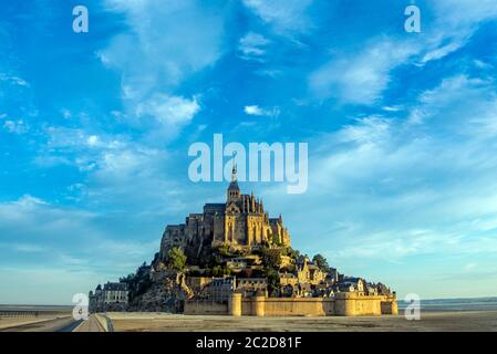 Alba a Mont Saint Michel e la sua Abbazia con il mare con la bassa marea Foto Stock