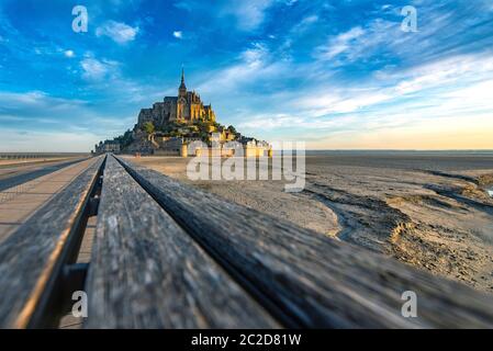 Strada che conduce al Mont Saint Michael con la sua abbazia e la bassa marea Foto Stock