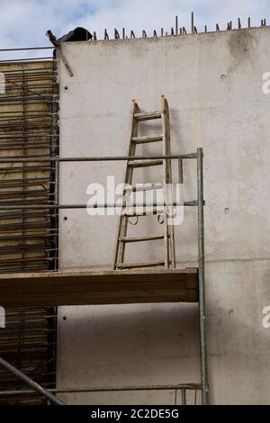 Scala sulla piattaforma superiore su una impalcatura Foto Stock