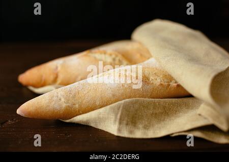 Pane appena sfornato baguette. Due appena sfornato baguette avvolto in una panetteria. Prodotti da forno Foto Stock