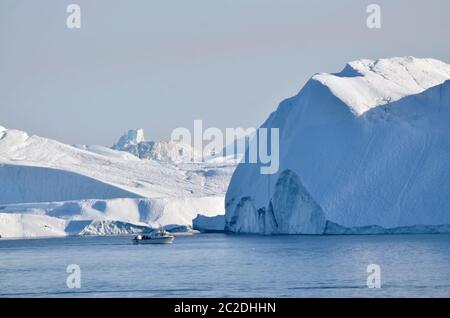 Boot vor Eisberge in der Diskobucht, Grönland Foto Stock