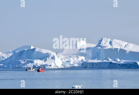 Boote vor den Eisbergen in der Diskobucht, Grönland Foto Stock