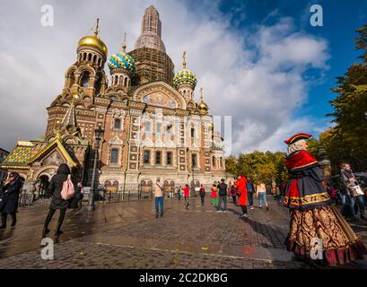 Turista alla Chiesa del Salvatore sulla facciata di sangue versato con donna vestita in costume d'epoca come attrazione turistica, San Pietroburgo, Russia Foto Stock